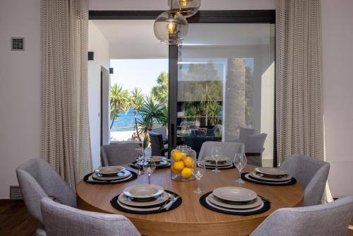 een eetkamer met een tafel met stoelen en een eetkamer bij Unforgettable Tinos beach houses complex in Agios Ioannis