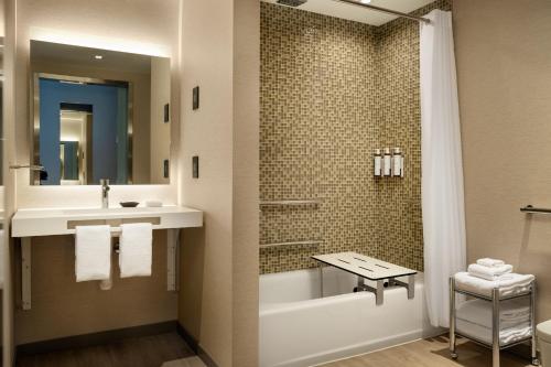 uma casa de banho com uma banheira, um lavatório e um chuveiro em AC Hotel by Marriott Oakland Downtown em Oakland
