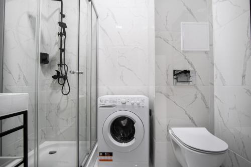 a bathroom with a washing machine in a shower at Dream Apartments - Gdańska 72 in Łódź