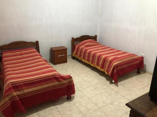 Habitación con 2 camas y TV. en Casa “El Rodeo” en Rodeo