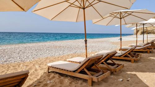 un gruppo di sedie e ombrelloni in spiaggia di PARADISE premium apartment a Villajoyosa