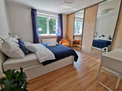 Apartamenty Kotarz في برينا: غرفة نوم بسرير ومرآة