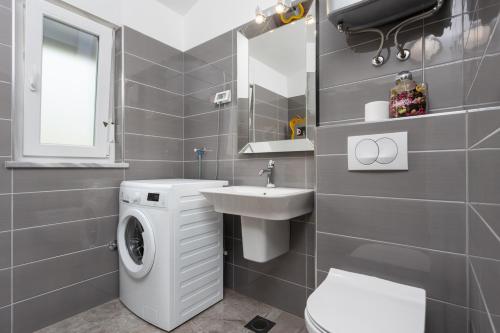 łazienka z pralką i umywalką w obiekcie Villa LM w mieście Krnica