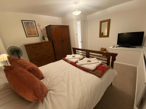 um quarto com uma cama branca e toalhas em Close to sea and South Downs national park - Sompting em Sompting