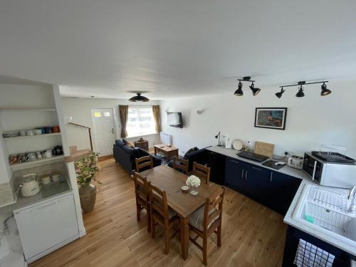 uma cozinha e uma sala de estar com uma mesa num quarto em Close to sea and South Downs national park - Sompting em Sompting
