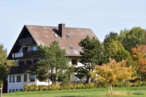 una grande casa con tetto di gambero di Hotel Wildenburger Hof a Kempfeld
