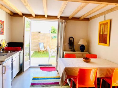 une cuisine avec une table et des chaises orange dans l'établissement Studio à Anglet très lumineux avec jardinet, à Anglet