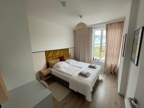 Habitación pequeña con cama y ventana en Modern Tower Apartament Gdynia, en Gdynia