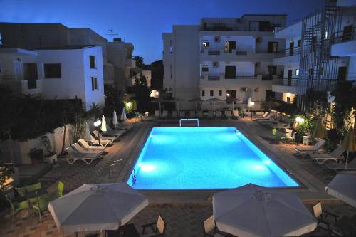 a swimming pool in front of a building at night at Santa Marina Hotel Apartments in Kos Town