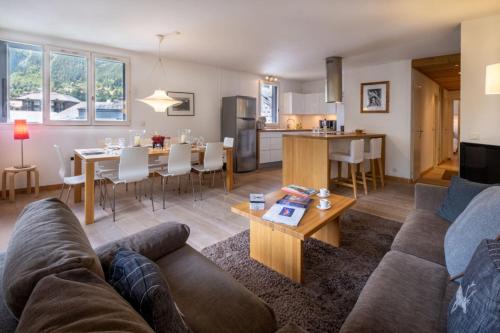 un salon et une cuisine avec un canapé et une table dans l'établissement T3 with breathtaking views of Mont Blanc, à Chamonix-Mont-Blanc