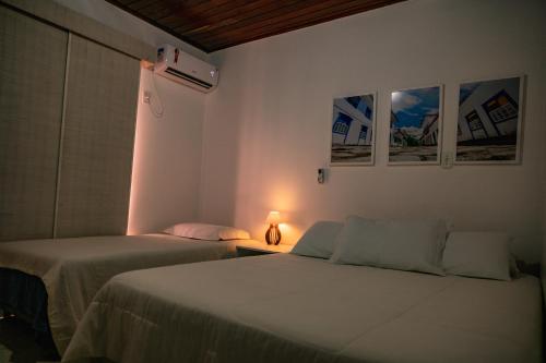 1 dormitorio con 2 camas y una lámpara en una mesa en Duplex na beira da praia, de frente pro mar, en Salvador