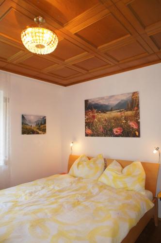 Alpenvilla Tirol Zentral في فولس: غرفة نوم بسرير وثريا