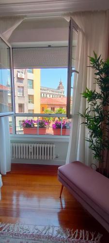 a living room with a window with a view of a building at Oviedo Centro- Parking gratuito in Oviedo