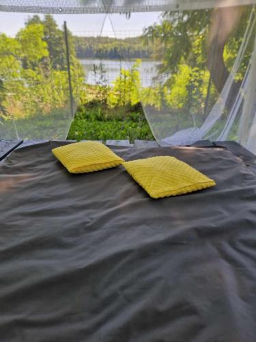 a bed with two yellow pillows on top of it at DOMEK W JERSEY PRZY PLAŻY in Wieleń