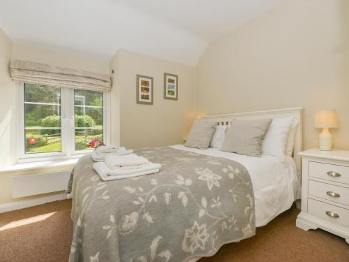 a bedroom with a bed and a window at Woodedge in Minehead