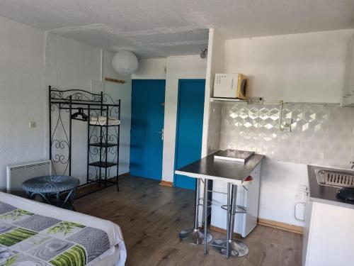 Habitación pequeña con cocina y cama en Idéal Vacances petit budget, en La Grande-Motte
