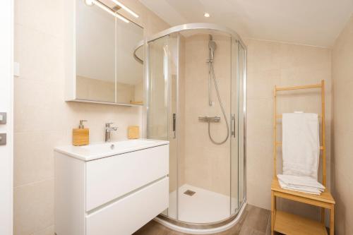 a white bathroom with a shower and a sink at Easy in Mali Lošinj
