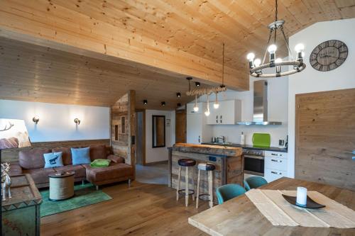 a kitchen and living room with wooden ceilings at Der Bräuschmied in Lofer