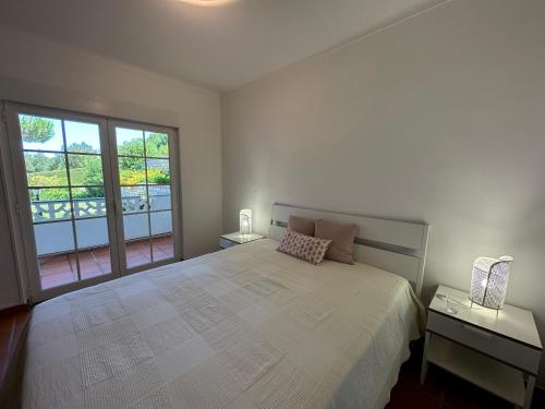 um quarto com uma cama grande e uma janela grande em Best Houses 91 - Casa D'el Rey em Amoreira