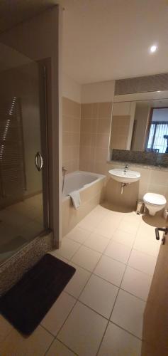 a bathroom with a tub and a toilet and a sink at Central Prime King Size Apartment in Dublin