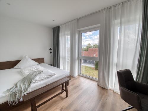 a bedroom with a bed and a large window at Gästehaus linda&otto in Achim
