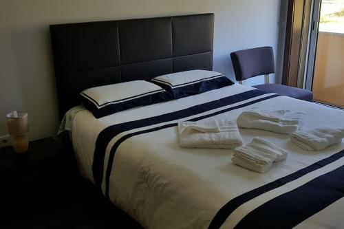 ein Schlafzimmer mit einem großen Bett mit Handtüchern darauf in der Unterkunft Furadouro Beach Apartment in Ovar