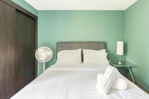 1 dormitorio con 1 cama blanca grande y ventilador en Amazing 2BR view to Parque España in Condesa, en Ciudad de México