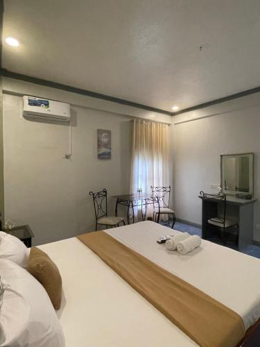 1 dormitorio con 1 cama grande y toallas. en La Playita Resort, en Lalauigan