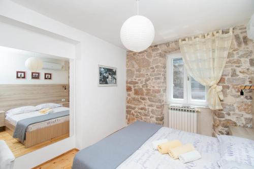 1 dormitorio con 2 camas y pared de piedra en Apartment Julija, en Vodice