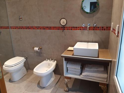 a bathroom with a white toilet and a sink at Indigo CCH in Carpintería