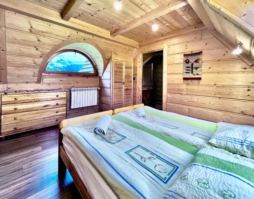 ein Schlafzimmer mit einem Bett in einer Holzhütte in der Unterkunft Bartusiowa Osada in Zakopane