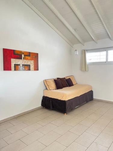 1 dormitorio con 1 cama en una habitación blanca en Apart Jazmines del Río en Santa Rosa de Calamuchita