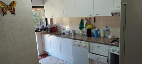 a kitchen with white cabinets and a counter top at Dream House by Douro Valley in Rio Mau