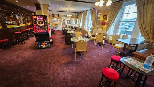 a restaurant with tables and chairs and a bar at NELSON Hotel in Great Yarmouth