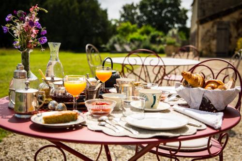 Saint-Félix-de-VilladeixにあるLes Cieux de Saint-Félix, Maison d'Hôtes & SPAのピンクのテーブル(食べ物、飲み物付)