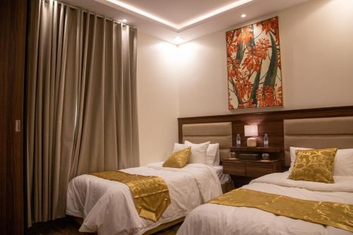Habitación de hotel con 2 camas y ventana en صالة وغرفتين نوم دخـول ذاتي, en Al Kharj