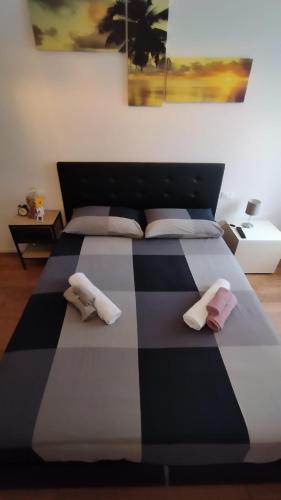 a black and white bed with two towels on it at In viaggio con Pippo - Ampio appartamento con AC nei pressi di Piazza Bovio e del Rivellino in Piombino