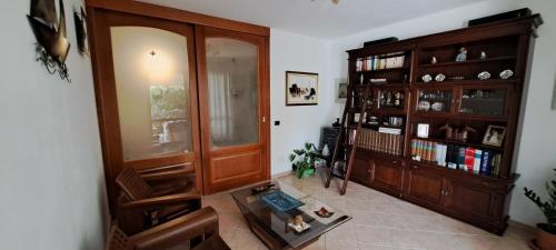 a living room with a book shelf and a table at B&B Brezza di Mare (Sea Breeze) in Villasimius