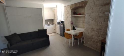 een keuken en een woonkamer met een bank en een tafel bij Garibaldi 5 in Giovinazzo