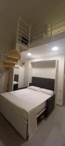 a bedroom with a large bed with a staircase at Garibaldi 5 in Giovinazzo
