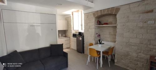een woonkamer met een bank en een tafel en een keuken bij Garibaldi 5 in Giovinazzo