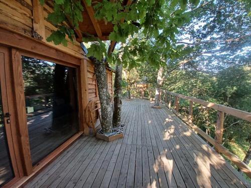 a wooden deck with a tree on the side of a house at IRATIKO KABIAK in Orbaiceta