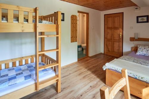 a room with two bunk beds and a desk at Chata Harmonie in Bedřichov