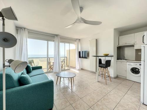 un salon avec un canapé bleu et une table dans l'établissement Studio 4 couchages face mer Noumarie, à Canet