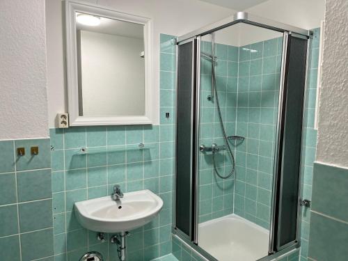 La salle de bains est pourvue d'un lavabo et d'une douche. dans l'établissement Haus Seelöwe Wohnung 1, à Wittdün