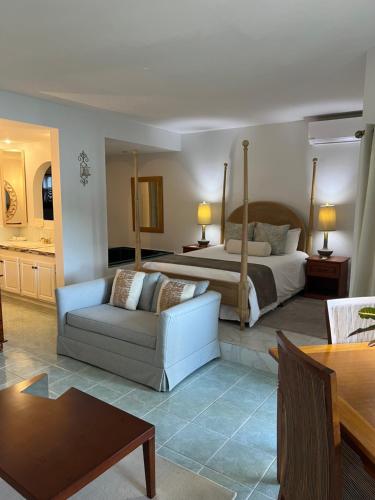 ein Hotelzimmer mit einem Bett, einem Sofa und einem Tisch in der Unterkunft Harmony Marina Suites in Rodney Bay Village