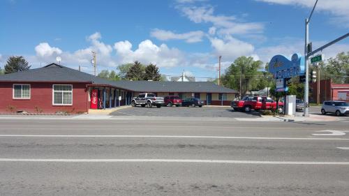 un bâtiment rouge avec des voitures garées dans un parking dans l'établissement Travelers Motel, à Elko