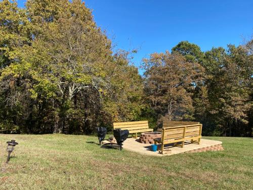 two benches in a park with trees in the background at Edelweiss Inn in Eureka Springs