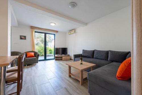 - un salon avec un canapé et une table dans l'établissement Petrovac Holiday Apartments 2, à Petrovac na Moru