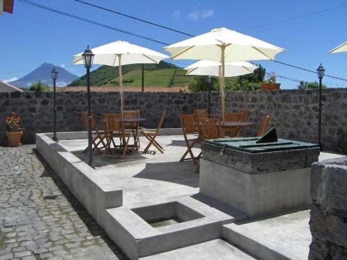 Quinta do Canto في أورتا: فناء فيه مظلات وطاولات وكراسي